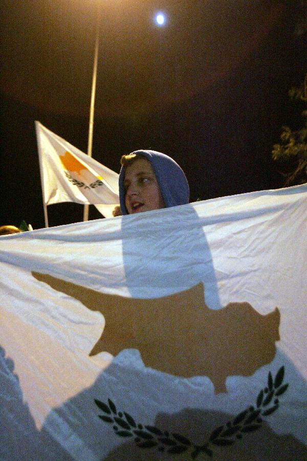 Cypriots protest in front of the office of the European Union, in Nicosia, Cyprus, on March 24, 2013. Some Cypriot banks have imposed a limit of 100 euros (130 U.S. dollars) on daily cash withdrawals from ATM machines, as crucial talks are underway in Brussels for a bailout accord. (Xinhua /Marios Lolos)