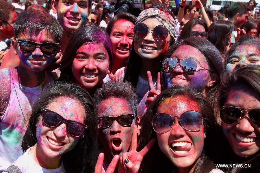 People with colored powder on their faces pose for photos during the Holi Festival in Pasay City, the Philippines, March 24, 2013. The Holi Festival is one of the major festivals in India, celebrating the turn of the seasons from winter to spring. Also known as the Festival of Colors, it is a fun-filled celebration during which hundreds of people gather to enjoy a day of dancing, eating and throwing colored powder at one another. (Xinhua/Rouelle Umali)