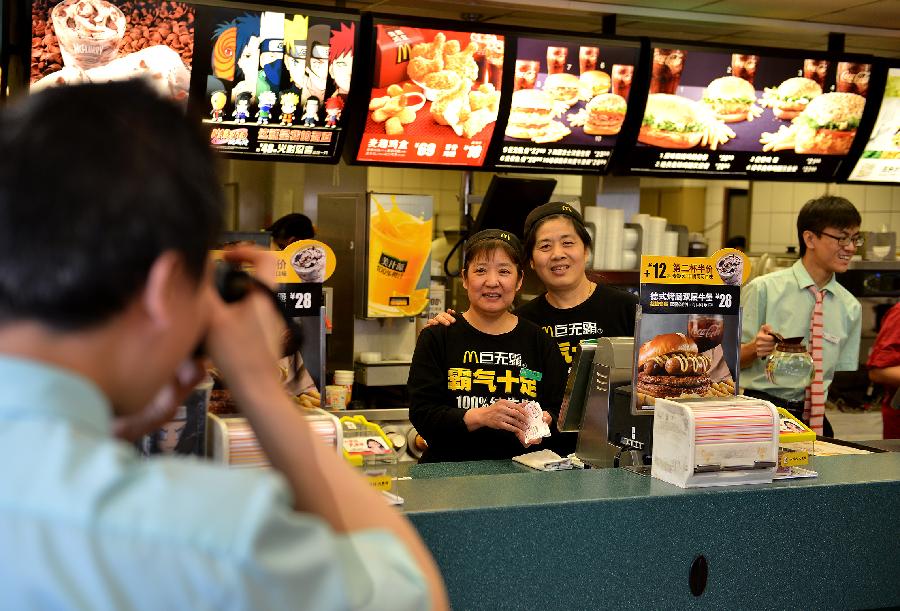 Staffers pose for a photo during their break at the McDonald's restaurant at Chang'an Market in Beijing, capital of China, March 24, 2013. Opened in 1993 as the second outlet of the American fast-food giant in Beijing, the Chang'an Market McDonald's made indelible impressions on locals. Due to reconstruction and adjustment of the market, the outlet discontinued its business Sunday. (Xinhua/Li Xin)