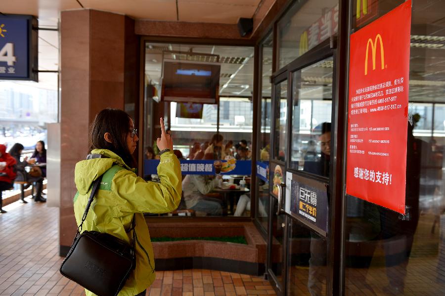 A customer takes a photo of a closure notice on a window of the McDonald's restaurant at Chang'an Market in Beijing, capital of China, March 24, 2013. Opened in 1993 as the second outlet of the American fast-food giant in Beijing, the Chang'an Market McDonald's made indelible impressions on locals. Due to reconstruction and adjustment of the market, the outlet discontinued its business Sunday. (Xinhua/Li Xin)