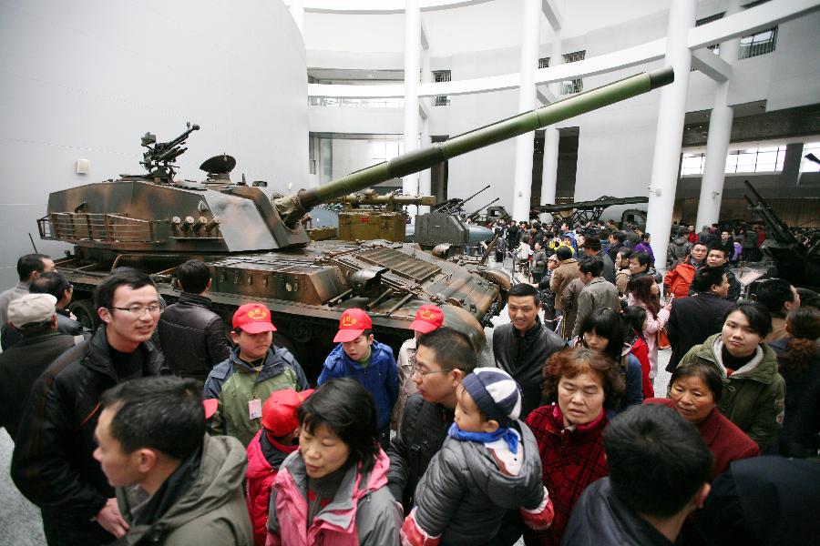 Tourists visit a tank at the weapon museum of Nanjing University of Science and Technology (NJUST) in Nanjing, capital of east China's Jiangsu Province, March 24, 2013. The NJUST opened to public to celebrate its 60th anniversary Sunday. The weapon museum collects about 6,000 weapons since the First World War. (Xinhua/Wang Xin)