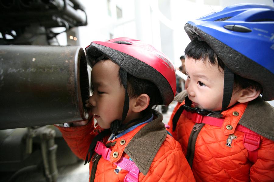 Two children watch a gun barrel at the weapon museum of Nanjing University of Science and Technology (NJUST) in Nanjing, capital of east China's Jiangsu Province, March 24, 2013. The NJUST opened to public to celebrate its 60th anniversary Sunday. The weapon museum collects about 6,000 weapons since the First World War. (Xinhua/Wang Xin)