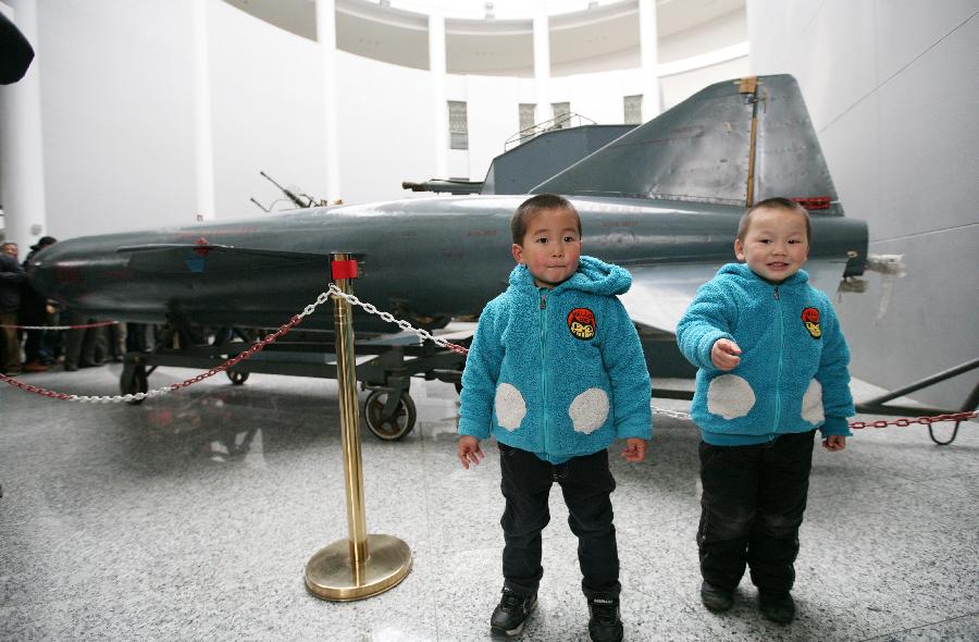 Two boys visit a missile at the weapon museum of Nanjing University of Science and Technology (NJUST) in Nanjing, capital of east China's Jiangsu Province, March 24, 2013. The NJUST opened to public to celebrate its 60th anniversary Sunday. The weapon museum collects about 6,000 weapons since the First World War. (Xinhua/Wang Xin)
