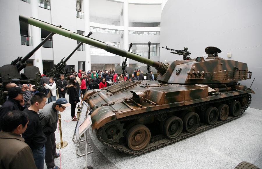 Tourists visit a tank at the weapon museum of Nanjing University of Science and Technology (NJUST) in Nanjing, capital of east China's Jiangsu Province, March 24, 2013. The NJUST opened to public to celebrate its 60th anniversary Sunday. The weapon museum collects about 6,000 weapons since the First World War. (Xinhua)