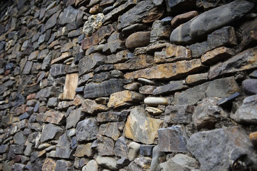 Photo taken on March 22, 2013 shows the wall of a stone house which is aged over 600 years in Yangda Village of Riwar Township in Suoxian County in the Nagqu Prefecture, southwest China's Tibet Autonomous Region. Three stone houses, each with the age exceeding more than 600 years, are preserved well in the village. (Xinhua/Liu Kun)