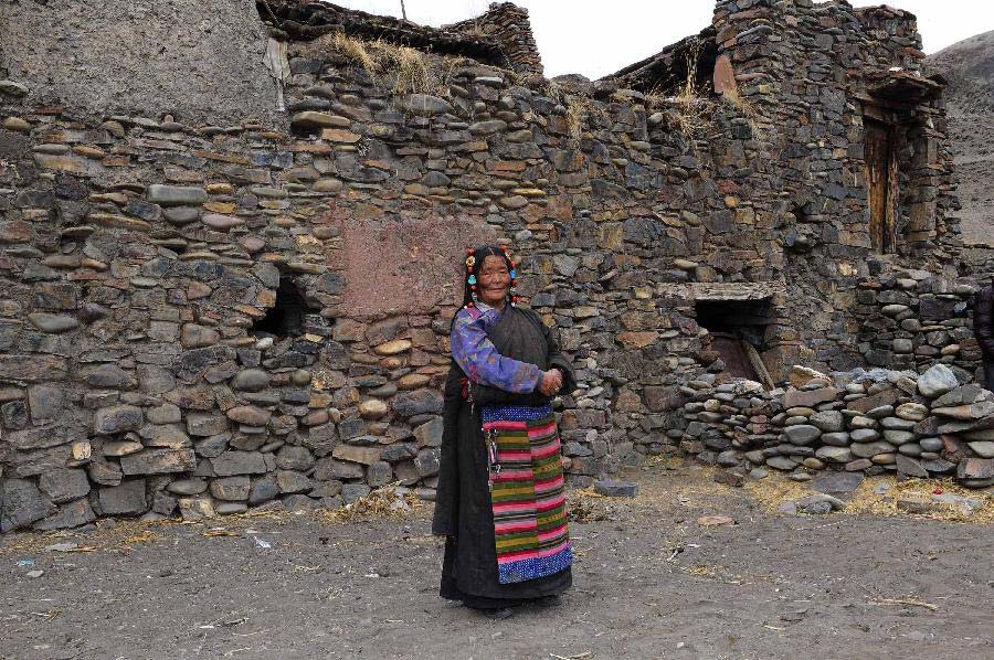 The 65-year-old Haji poses for photos in front of her stone house which is aged over 600 years in Yangda Village of Riwar Township in Suoxian County in the Nagqu Prefecture, southwest China's Tibet Autonomous Region. Three stone houses, each with the age exceeding more than 600 years, are preserved well in the village. (Xinhua/Liu Kun)