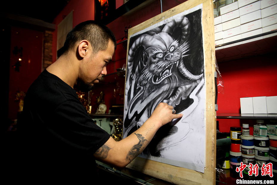 Liu Jinlong designs new patterns from time to time. Tattooing, which has been practiced in most parts of the world, is now having coteries in China. (Photo by Guo Zeyuan/Chinanews.com)