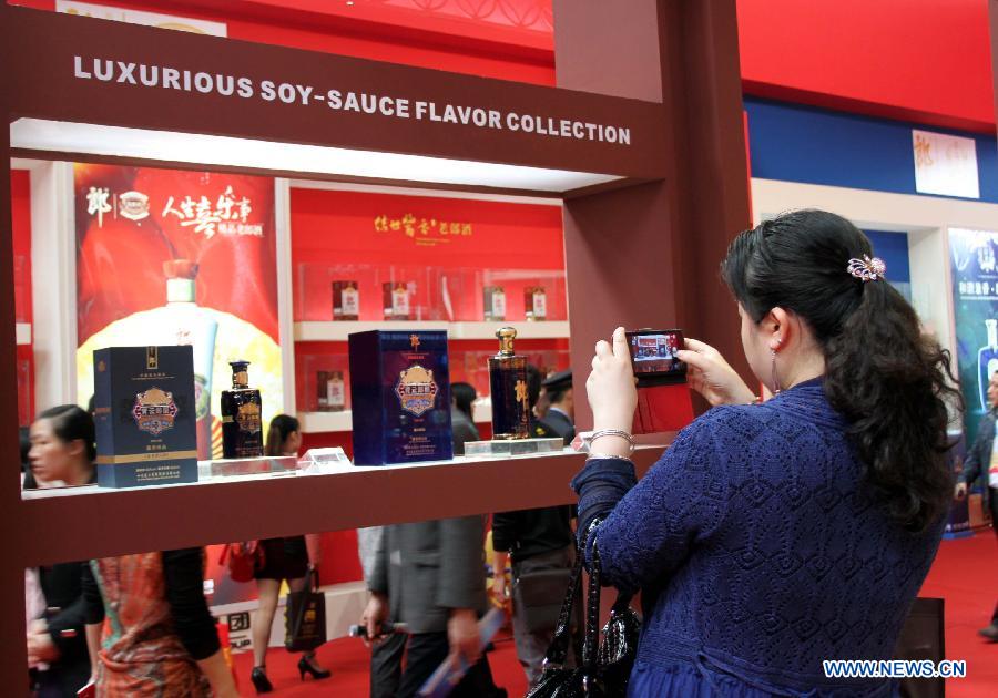 A visitor takes photos of liquor products displayed during a liquor expo of the 14th Western China International Fair (WCIF) in Luzhou, southwest China's Sichuan Province, March 25, 2013. More than 300 liquor producers attended the event, which was inaugurated Monday in Luzhou. (Xinhua/Liu Hai)