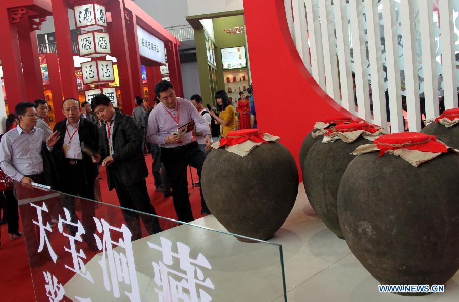 Visitors look at liquor products displayed during a liquor expo of the 14th Western China International Fair (WCIF) in Luzhou, southwest China's Sichuan Province, March 25, 2013. More than 300 liquor producers attended the event, which was inaugurated Monday in Luzhou. (Xinhua/Liu Hai)