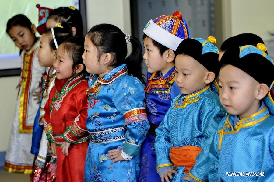 Children wearing costumes of Mongolian ethnic group perform during a class at a kindergarten in Hohhot, capital of north China's Inner Mongolia Autonomous Region, March 25, 2013. The region has promoted education on ethnic culture for kindergarten children of Mongolian ethnic group, by offering children classes on folk music, dance and drawing. (Xinhua/Zhao Tingting) 