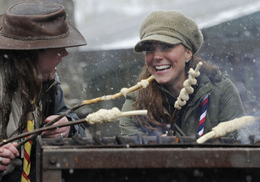 Catherine, Duchess of Cambridge, joins in the preparation of campfire food during a visit to the Great Tower Scout camp at Newby Bridge in Cumbria on March 22, 2013. The Duchess braved snowy conditions to pay a visit to the scout camp. (Xinhua/AFP)
