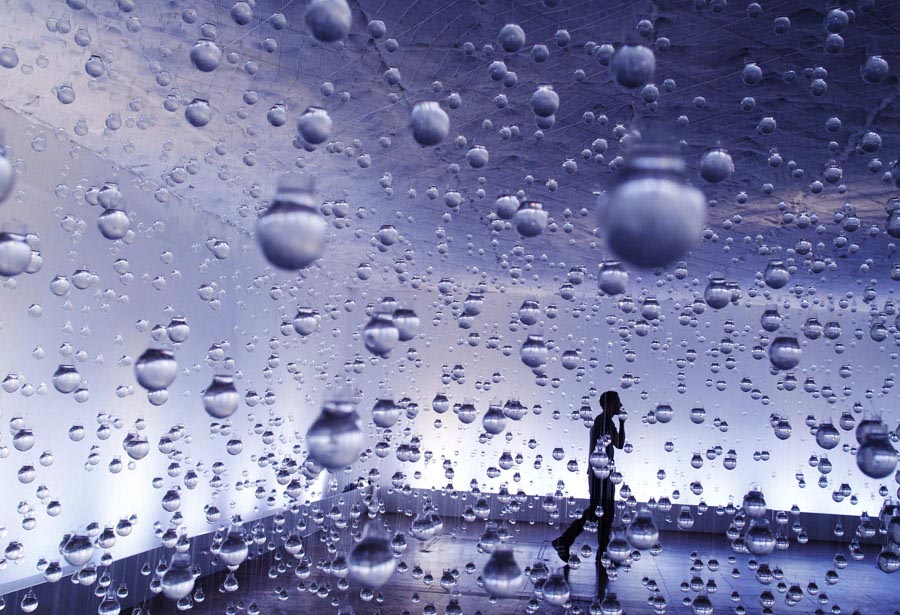 On March 24, 2013，a man walks among light bulbs filled with water as part of the 'Lagrimas de Sao Pedro' exhibit by Brazilian artist Vinicius Silva in Rio de Janeiro. (Xinhua/AFP)