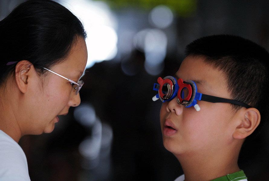 On July 28, 2010, the ophthalmic clinic at Jiaxing TCM hospital, Zhejiang, sees crowds gathered in every corner because a great many children were taken there for eye examination. Since the beginning of the summer vacation, the clinic has examined the eyes of hundreds of students every day. The major reasons for fading eyesight and ophthalmic diseases are the long hours spent on watching TV, working on the computer and playing video games. (Zhejiang Daily/Chu Yongzhi)