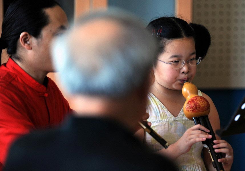 On July 17, 2010, children are not seen relaxing during their summer vacation. Virtually all parents expected their children to develop a specialty, which contributes to the popularity of taking up traditional instruments. A girl is spotted learning how to play the cucurbit flute. (Zhejiang Daily/Chu Yongzhi)