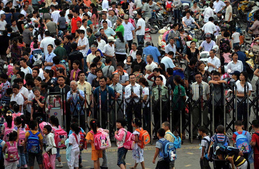On Aug. 31, 2009, students walking out of the Junru Primary School in Jiaxing, Zhejiang, after the new semester's registration process, are surrounded by their parents waiting outside. Every student carries the hopes of the family, with each step he or she takes, from birth to school, infused with their parents' painstaking efforts. Lest their children lose in the starting line, the parents deem the education the most significant issue in their lives. (Zhejiang Daily/Chu Yongzhi)