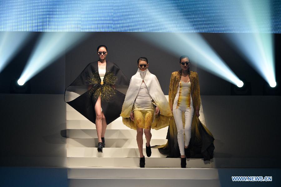 Models present creations of designers attending the 21st China International Young Fashion Designers Contest in Beijing, capital of China, March 25, 2013. The contest theming Boundary has attracted 29 designers from 16 countries. (Xinhua/Li Xin)
