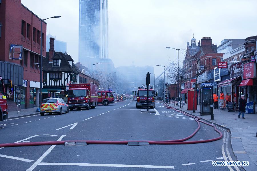 Firefighters extinguish fire at a building in Walworth, south east London, Britain, on March 25, 2013. There are currently no indications of how the fire started and no injuries have been reported, a fire brigade spokesman said. (Xinhua/He Yining)