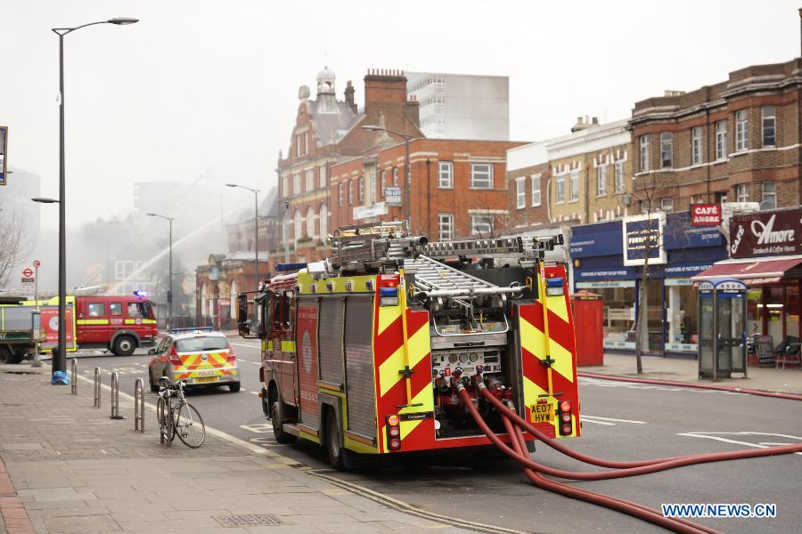 Firefighters extinguish fire at a building in Walworth, south east London, Britain, on March 25, 2013. There are currently no indications of how the fire started and no injuries have been reported, a fire brigade spokesman said. (Xinhua/He Yining) 