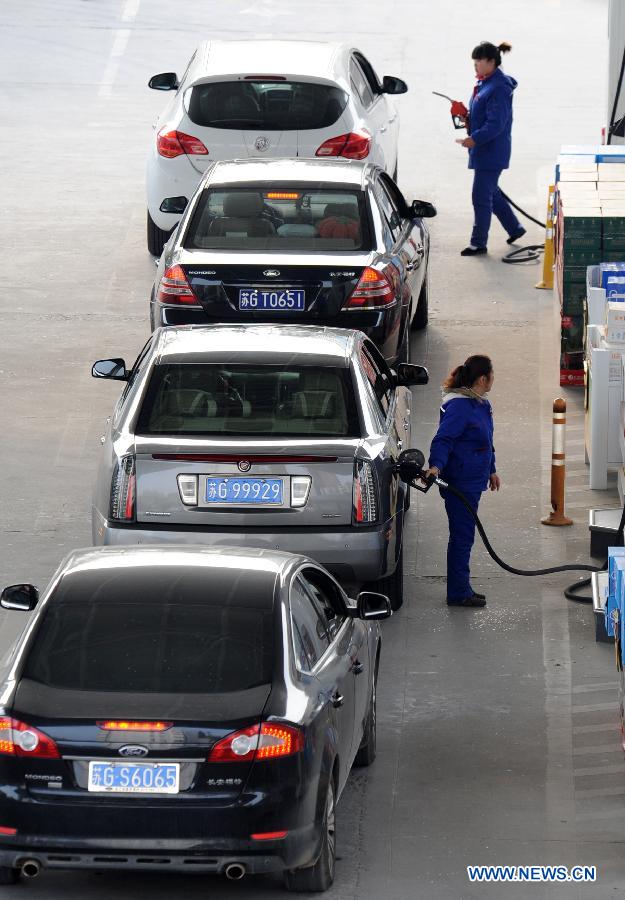 Cars line up waiting to refuel at a gas station in Lianyungang, east China's Jiangsu Province, March 26, 2013. China will cut the retail prices of gasoline by 310 yuan (49.43 U.S. dollars) per tonne and diesel by 300 yuan per tonne starting Wednesday, lowering the retail prices. (Xinhua/Geng Yuhe)