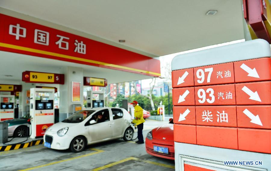An attendant refuels a car at a gas station in Hangzhou, capital of east China's Zhejiang Province, March 26, 2013. China will cut the retail prices of gasoline by 310 yuan (49.43 U.S. dollars) per tonne and diesel by 300 yuan per tonne starting Wednesday, lowering the retail prices. (Xinhua/Long Wei)