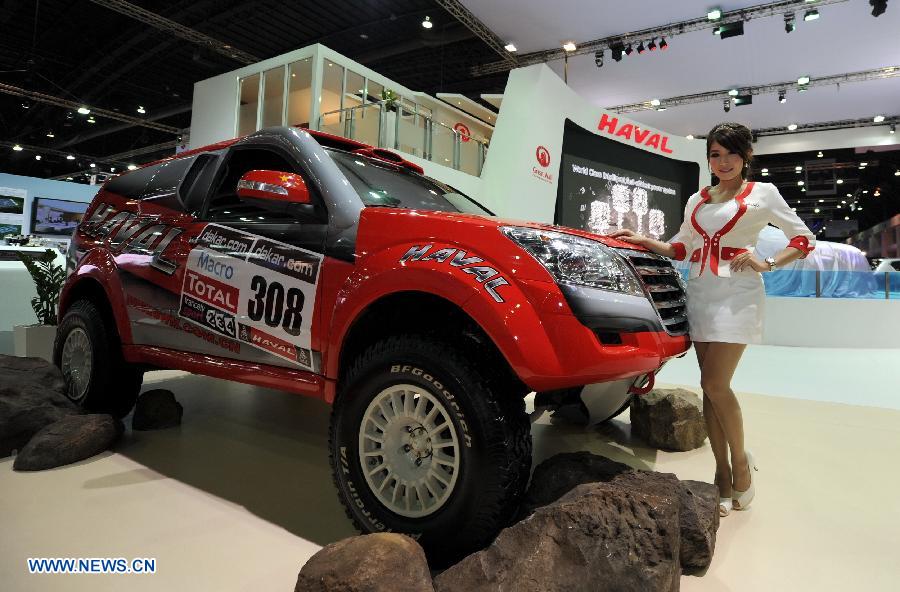 A model poses beside an SUV of Great Wall Motor during the press preview of the 34th Bangkok International Motor Show in Bangkok, Thailand, on March 26, 2013. The 34th Bangkok International Motor Show will be held from March 27 to April 7. (Xinhua/Gao Jianjun) 