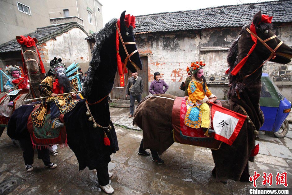 A "horse troop" parade in Qiqiao village of Nanjing attracted villages' attention on March 24, 2013. Big Horse Lantern (Da Ma Deng) is a folk arts form which began in Tang dynasty and got popular in Qing and Ming dynasties. The horse troop consists of seven "horses", and two people dressed as one horse. Child actors dressed up as historical figures, wave flags and whip horses to trot as if they were in the battle. (Xinhua / Yang Bo)  