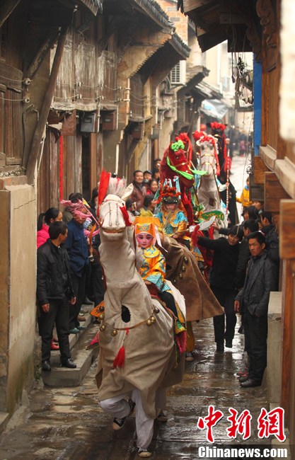 A "horse troop" parade in Qiqiao village of Nanjing attracted villages' attention on March 24, 2013. Big Horse Lantern (Da Ma Deng) is a folk arts form which began in Tang dynasty and got popular in Qing and Ming dynasties. The horse troop consists of seven "horses", and two people dressed as one horse. Child actors dressed up as historical figures, wave flags and whip horses to trot as if they were in the battle. (Xinhua / Yang Bo) 