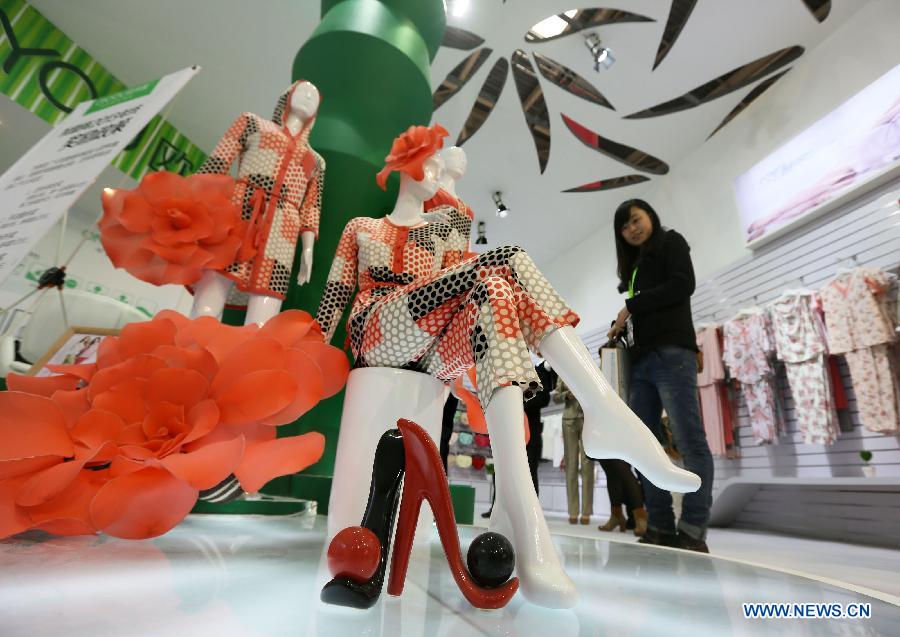  A visitor looks at dresses made of bamboo fiber during the China International Clothing & Accessories Fair (CHIC) in Beijing, capital of China, March 26, 2013. Over 1,000 clothing brands from 18 countries and regions took part in the four-day event which kicked off on Tuesday. (Xinhua) 