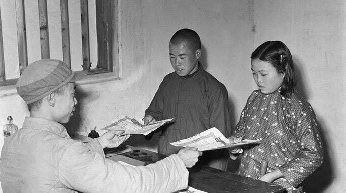 Farmer Quan Yusheng (middle) and Sun Guihua from Liling county of Hunan province register for marriage in 1952. The staff gave them the marriage certificate. (Photo/Global Times)