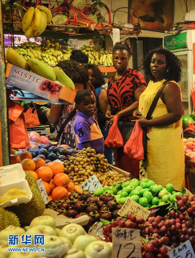 African women and children purchase fruits in a market. (Xinhua/ Liu Dawei)