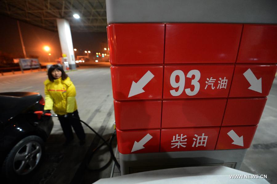 A staff member refuels a car at a gas station in Hefei, capital of east China's Anhui Province, March 27, 2013. China cut the retail prices of gasoline by 310 yuan (49.43 U.S. dollars) per tonne and diesel by 300 yuan per tonne starting Wednesday. The National Development and Reform Commission (NDRC) also announced a new pricing system which will adjust the prices of oil products every 10 working days to better reflect changes in the global oil market. (Xinhua/Zhang Duan)