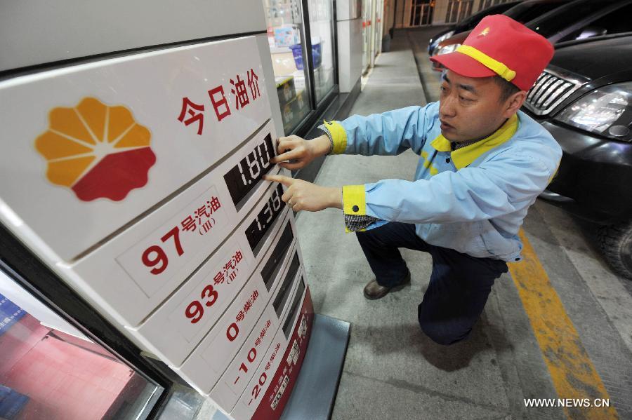 A staff member adjusts an oil price indicator at a gas station in Yinchuan, capital of northwest China's Ningxia Hui Autonomous Region, March 27, 2013. China cut the retail prices of gasoline by 310 yuan (49.43 U.S. dollars) per tonne and diesel by 300 yuan per tonne starting Wednesday. The National Development and Reform Commission (NDRC) also announced a new pricing system which will adjust the prices of oil products every 10 working days to better reflect changes in the global oil market. (Xinhua/Peng Zhaozhi)