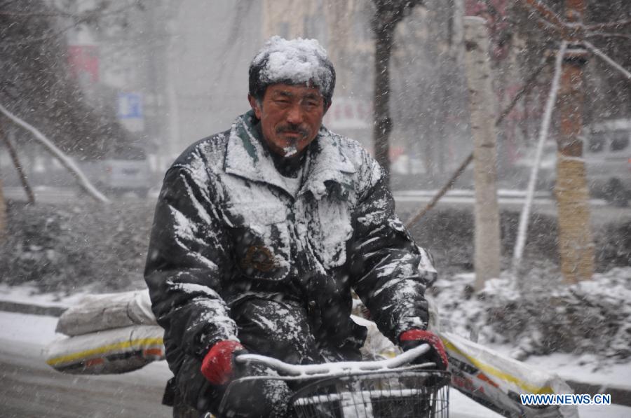 A citizen rides in snow in Jilin City, northeast China's Jilin Province, March 27, 2013. (Xinhua/Wang Mingming) 