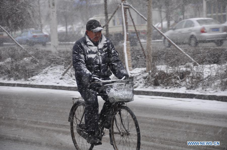 A citizen rides in snow in Jilin City, northeast China's Jilin Province, March 27, 2013. (Xinhua/Wang Mingming) 