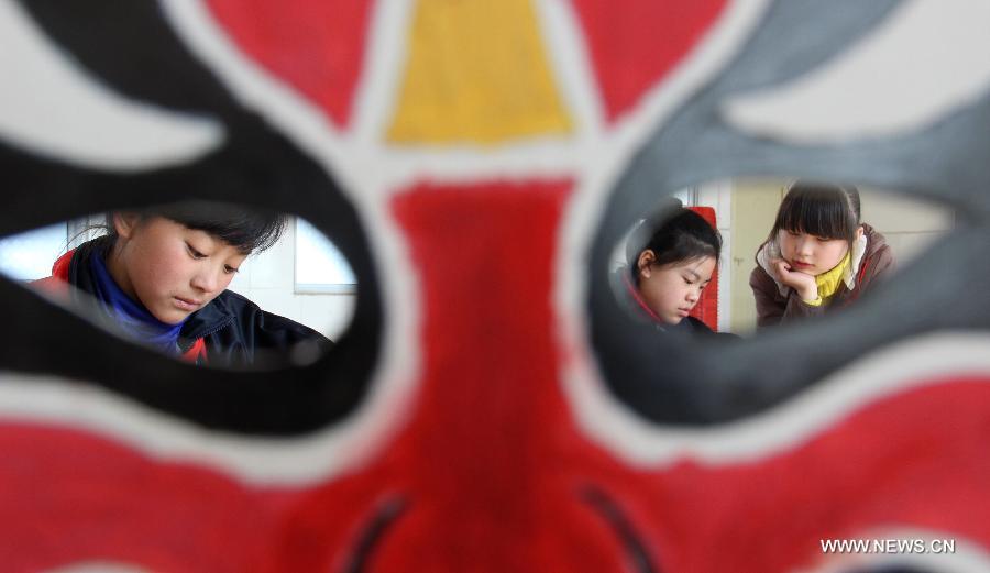 Students draw Beijing Opera facial masks at a primary school at Chengguan Town of Shiyan City, central China's Hubei Province, March 27, 2013, the World Theatre Day. Students here made the facial masks to learn more about traditional drama culture. (Xinhua/Cao Zhonghong) 