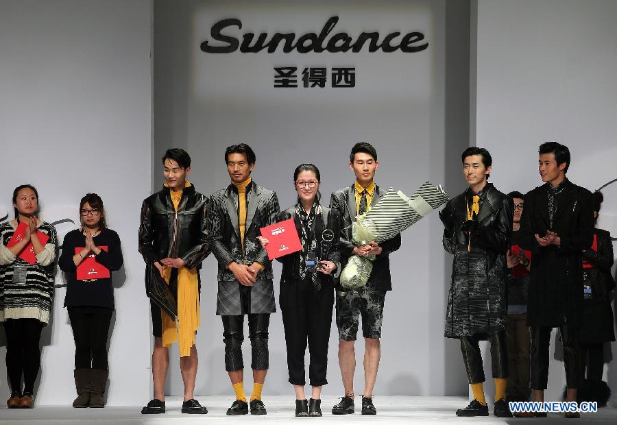 Gold award winner Wang Peng (5th L) poses for photos with models during the 2013 "Sundance Cup" China Fashion Business Men's Clothing Design Competition in Beijing, capital of China, March 27, 2013. A total of 600 creations participated in the competition held in Beijing on Thursday. (Xinhua/Wan Xiang)