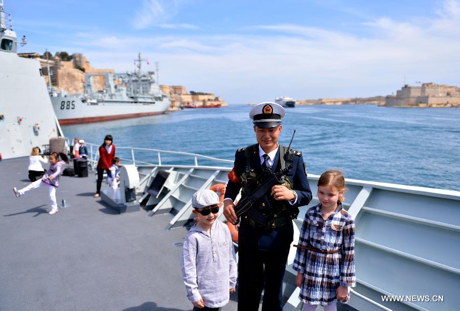 Children pose for photos with a Chinese naval soldier on the frigate "Hengyang" at the grand habour of Valletta, Malta, on March 27, 2013. An Open Day of the "Hengyang" for Maltese was held on Wednesday. The 13th naval escort squad, sent by the Chinese People's Liberation Army (PLA) Navy, arrived at Valletta of Malta on Tuesday for a five-day visit after finishing its escort missions. (xinhua/Xu Nizhi)