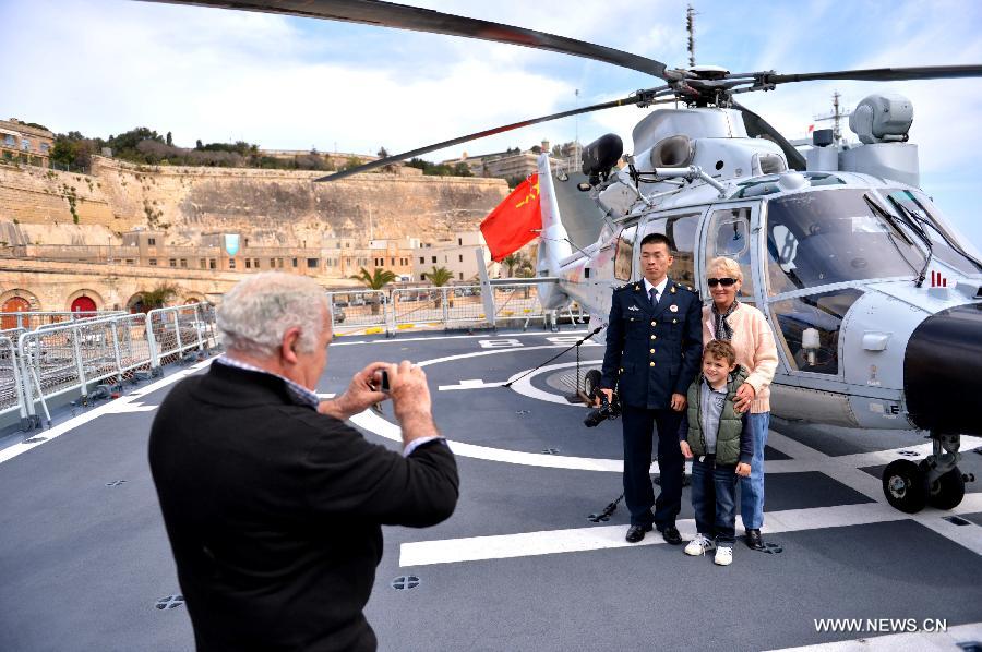 Visitors pose for photos with a Chinese naval soldier on the frigate "Hengyang" at the grand habour of Valletta, Malta, on March 27, 2013. An Open Day of the "Hengyang" for Maltese was held on Wednesday. The 13th naval escort squad, sent by the Chinese People's Liberation Army (PLA) Navy, arrived at Valletta of Malta on Tuesday for a five-day visit after finishing its escort missions. (xinhua/Xu Nizhi)