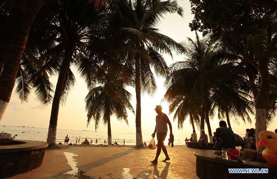 Visitors enjoy themselves on the seashore in Sanya City, south China's Hainan Province, March 27, 2013. (Xinhua/Chen Wenwu) 