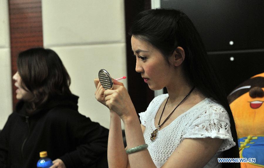 Singer Ren Miaoyin (R) does facial makeup prior to a live online concert in Beijing, capital of China, March 21, 2013. (Xinhua/Li Wen) 