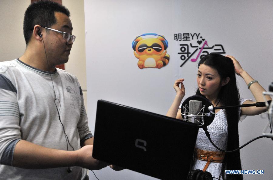 Singer Ren Miaoyin (R) makes preparations prior to a live online concert in Beijing, capital of China, March 21, 2013.(Xinhua/Li Wen) 