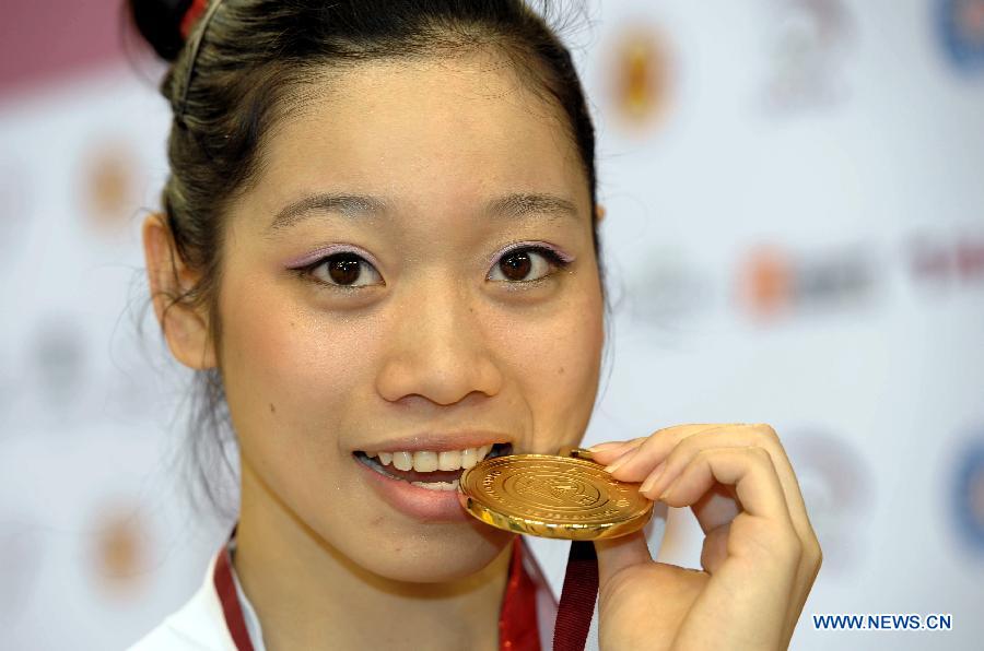 Phan Thi Ha Thanh of Vietnam reacts during the awarding ceremony for women's vault at the 6th FIG Artistic Gymnastics world Challenge Cup in Doha, Qatar, March 28, 2013. Phan Thi Ha Thanh claimed the title with 14.825 points. (Xinhua/Chen Shaojin)