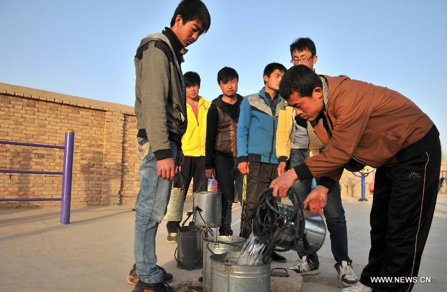 Students queue to get water beside a water well at the Junior High School of Shixiawan Township in Dingxi City, northwest China's Gansu Province, March 28, 2013. A drought lingering Gansu Province has caused 650,000 people lack of drinking water. (Xinhua/Chen Bin)