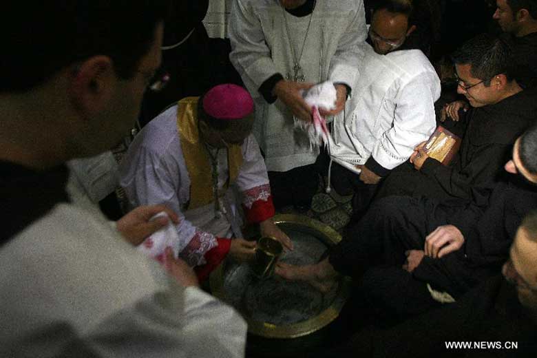 Latin Patriarch of Jerusalem Fouad Twal (L) washes the foot of a priest during the Catholic Washing of the Feet ceremony in the Church of the Holy Sepulchre in Jerusalem's Old City during Holy Week on March 28, 2013. Holy Week is celebrated in many Christian traditions during the week before Easter. [Photo:Xinhua/Muammar Awad]