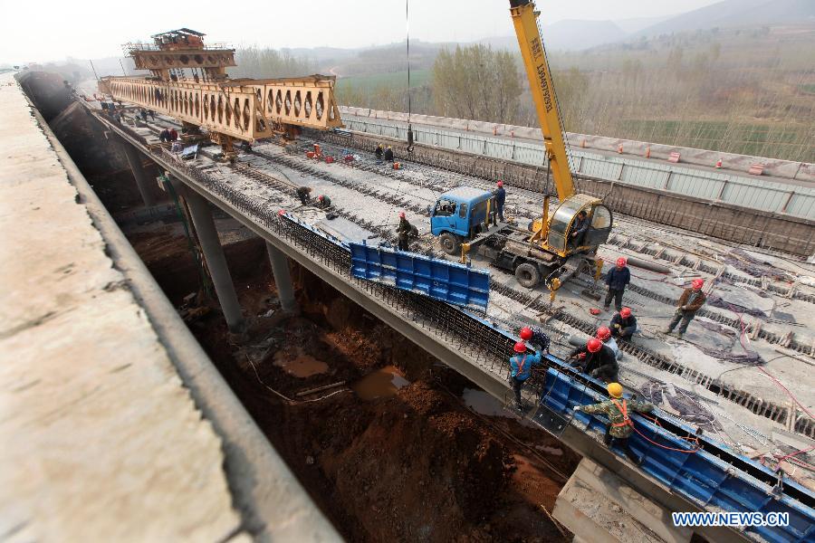 Workers repair the collapsed section of the southern lane of the Yichang Bridge on the Lianyugang-Horgos Highway in Sanmenxia City, central China's Henan Province, March 28, 2013. The Yichang New Bridge opened its two-way traffic on March 29 morning, after its construction passed the latest test. The 80-meter-long section of the old Yichang Bridge which was under repair collapsed after an explosion involving a fireworks-laden truck on Feb. 1. The accident claimed 13 lives. (Xinhua/Zhang Xiaoli)