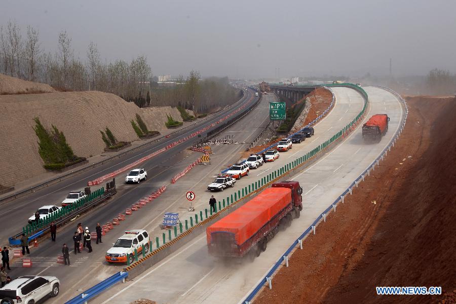 Trucks are led to the Yichang New Bridge on the Lianyugang-Horgos Highway in Sanmenxia City, central China's Henan Province, March 28, 2013. The Yichang New Bridge opened its two-way traffic on March 29 morning, after its construction passed the latest test. The 80-meter-long section of the old Yichang Bridge which was under repair collapsed after an explosion involving a fireworks-laden truck on Feb. 1. The accident claimed 13 lives. (Xinhua/Zhang Xiaoli)