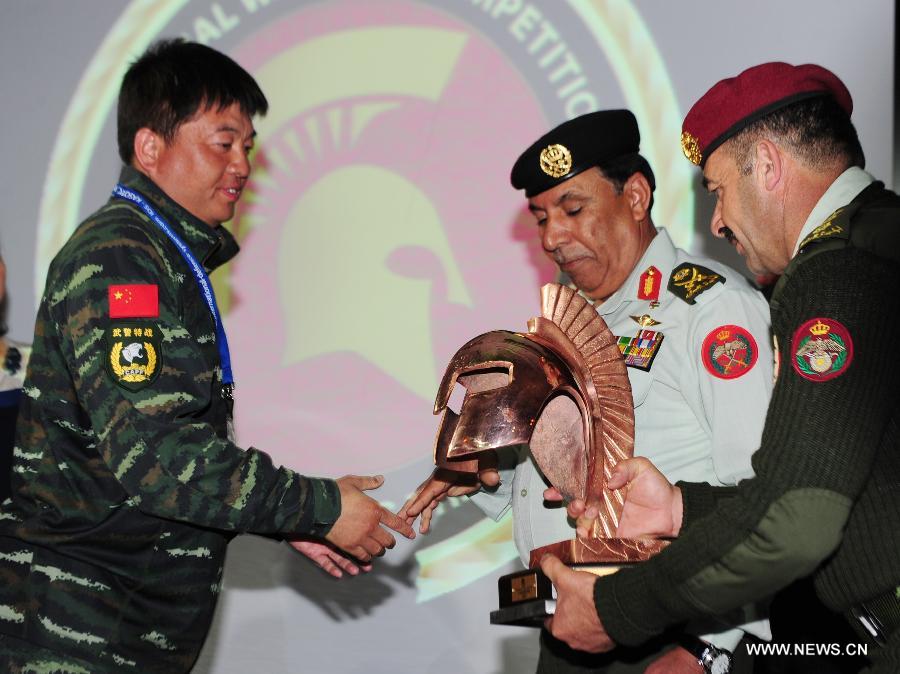 He Li (ast L), team leader of Chinese People's Armed Police team receives the first prize of the 5th Warrior Competition in Amman, Jordan, March 28, 2013. Chinese People's Armed Police team on Thursday won the first prize of fifth Warriors contest "international special forces contest at King Abdullah Special Operation Training Center (KASOTC) in Amman. The competition with wide participation of 33 teams from 18 countries was held from March 24 to March 28. (Xinhua/Cheng Chunxiang)  