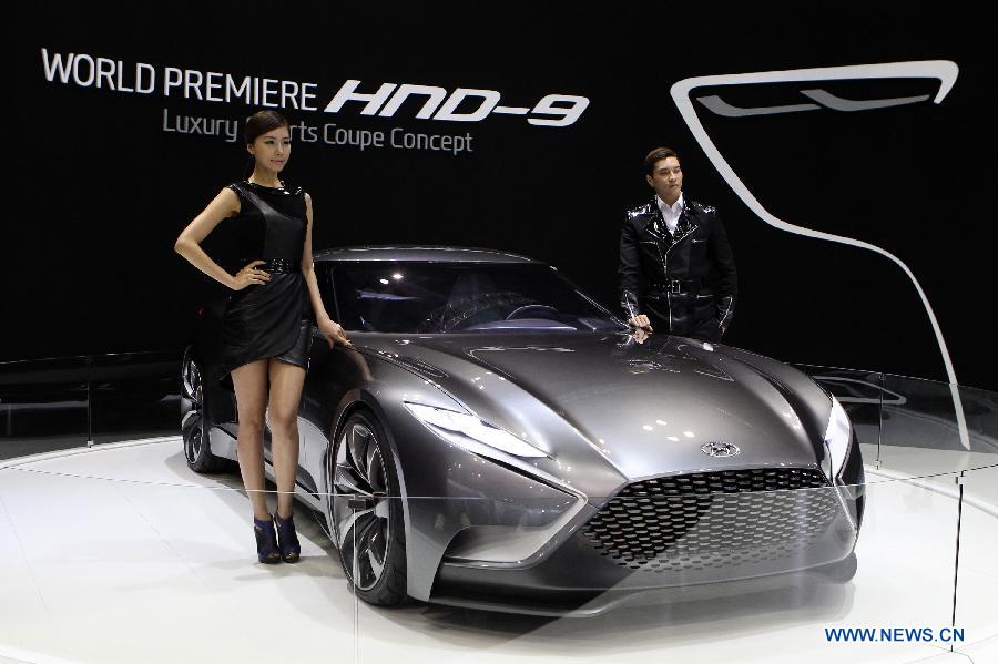 Models pose beside a Hyundai "HND-9" during the Seoul Motor Show in Goyang, South Korea, March 29, 2013. Seoul Motor Show 2013 runs from March 29 to April 7. (Xinhua/Park Jin-hee)