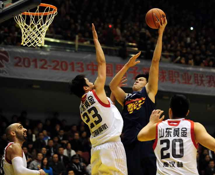A player of Guangdong team shoots as he is defended by the Shandong guards during the final of CBA basketball game in Jinan, East China's Shandong province, March 29, 2013. [Wu Jun / chinadaily.com.cn]