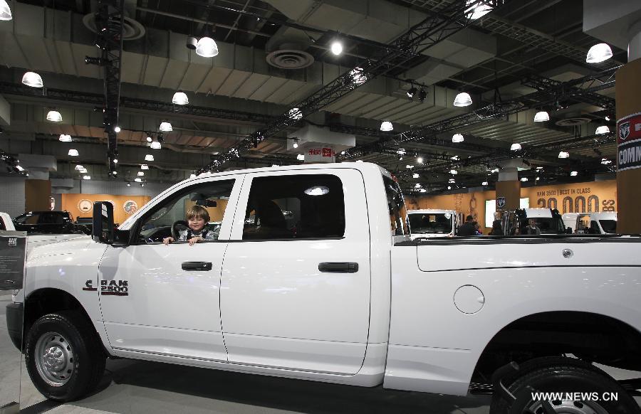 A boy plays in a Dodge RAM 2500 car during the 2013 New York International Auto Show in New York, on March 29, 2013. The 2013 New York International Auto Show opened to the public on Friday. (Xinhua/Cheng Li) 